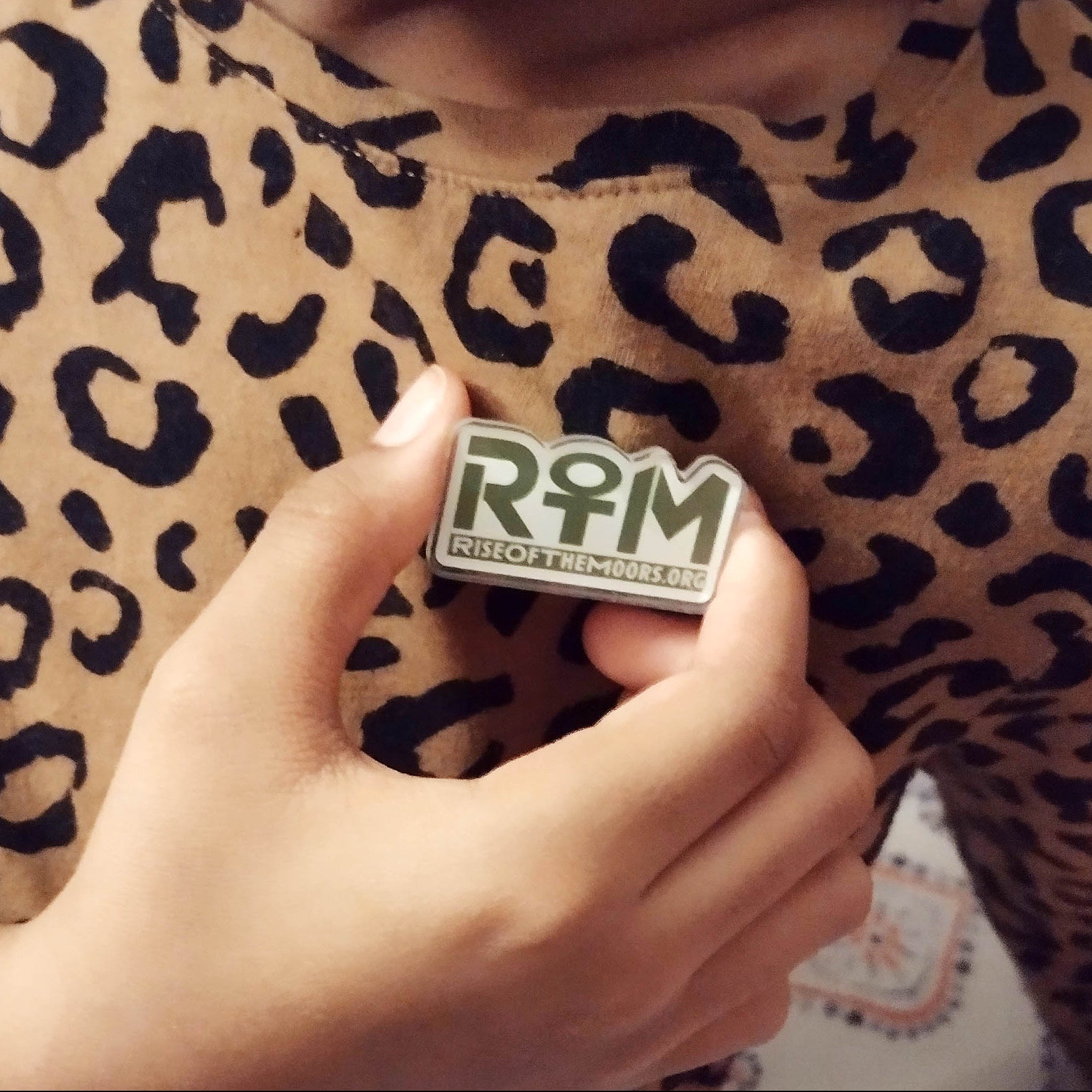 Person wearing a leopard print garment with a 'ROTM' logo badge.